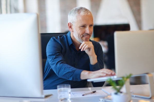 An independent educational consultant working at a desk in their office.